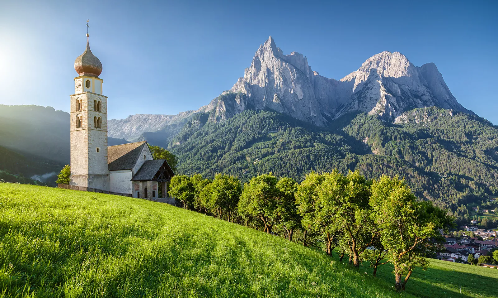 Rustic church next to a tall mountain in the background