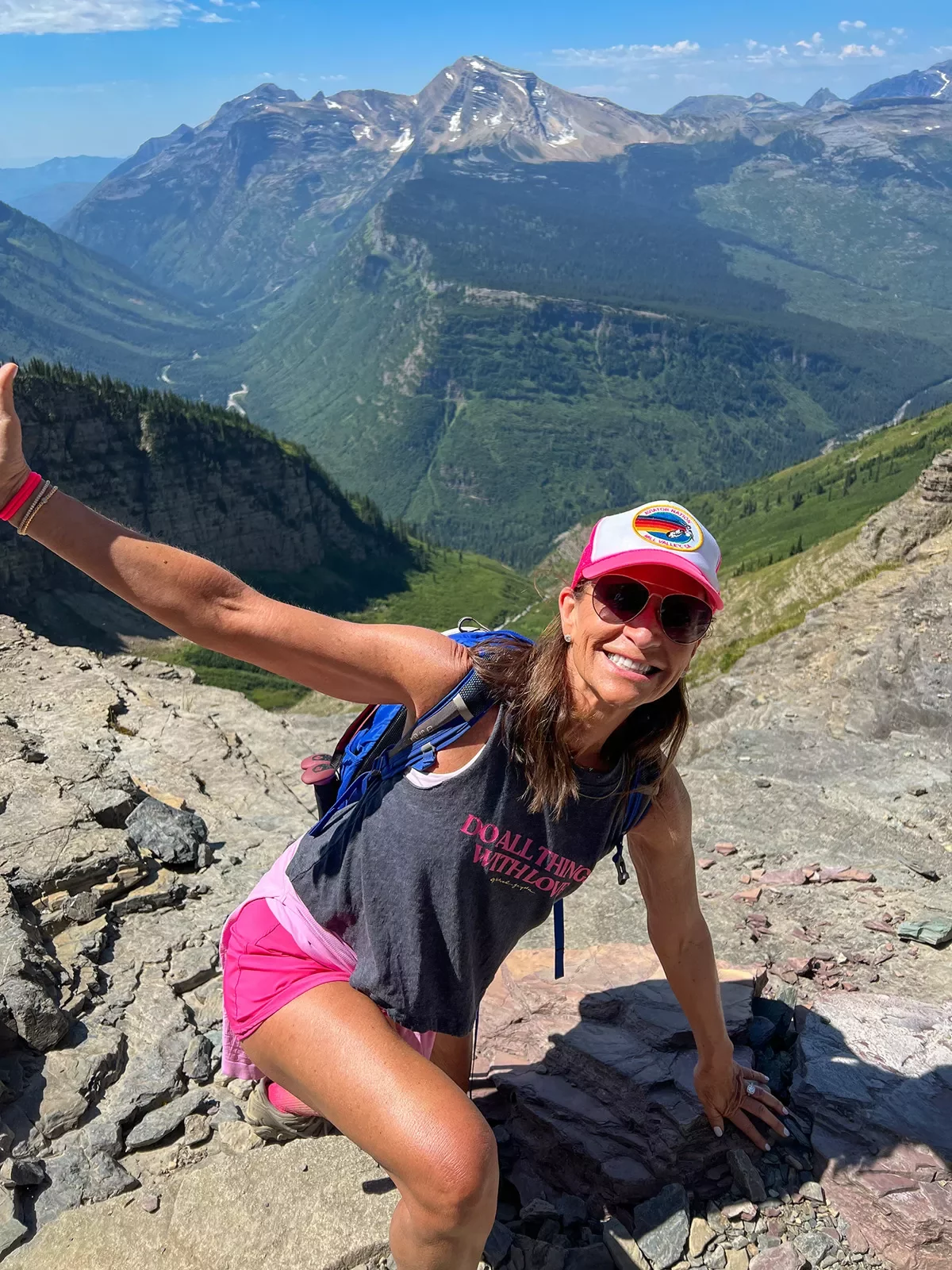 Women with her arms open and smiling on top of a hill