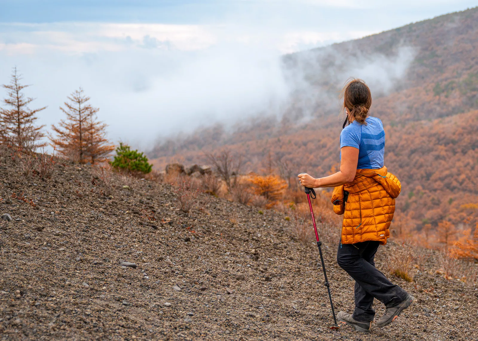 Woman ascending on a rocky, foggy hill