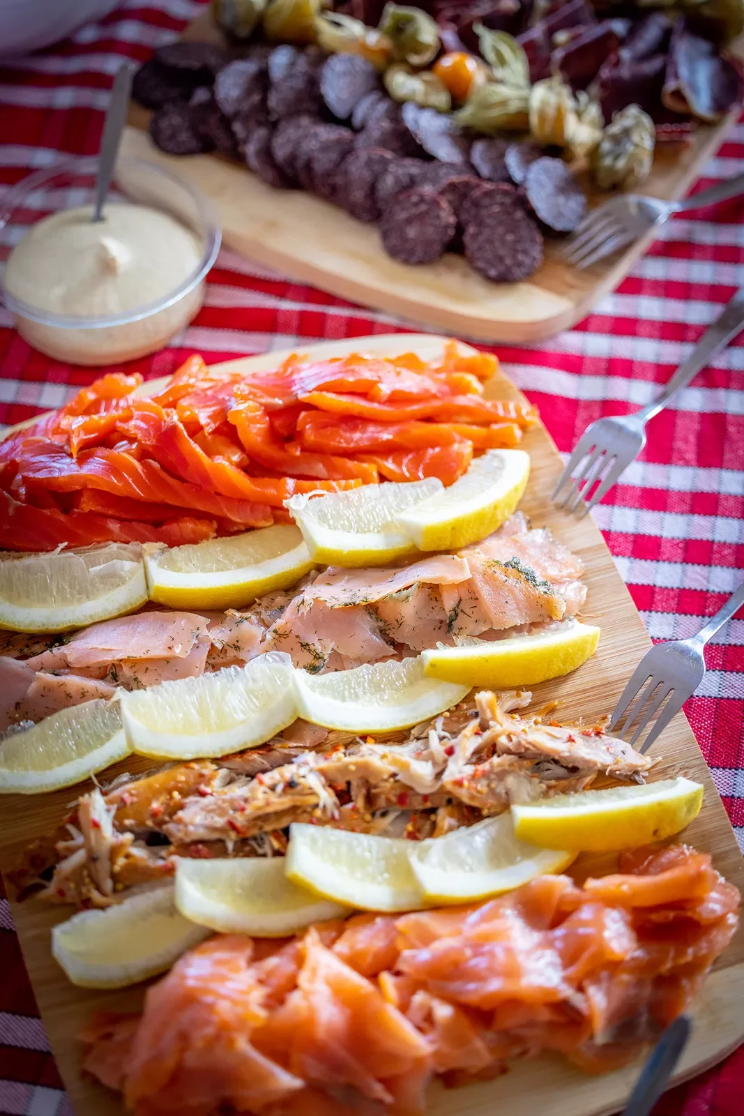 Wooden plank full of cured fish and lemon slices