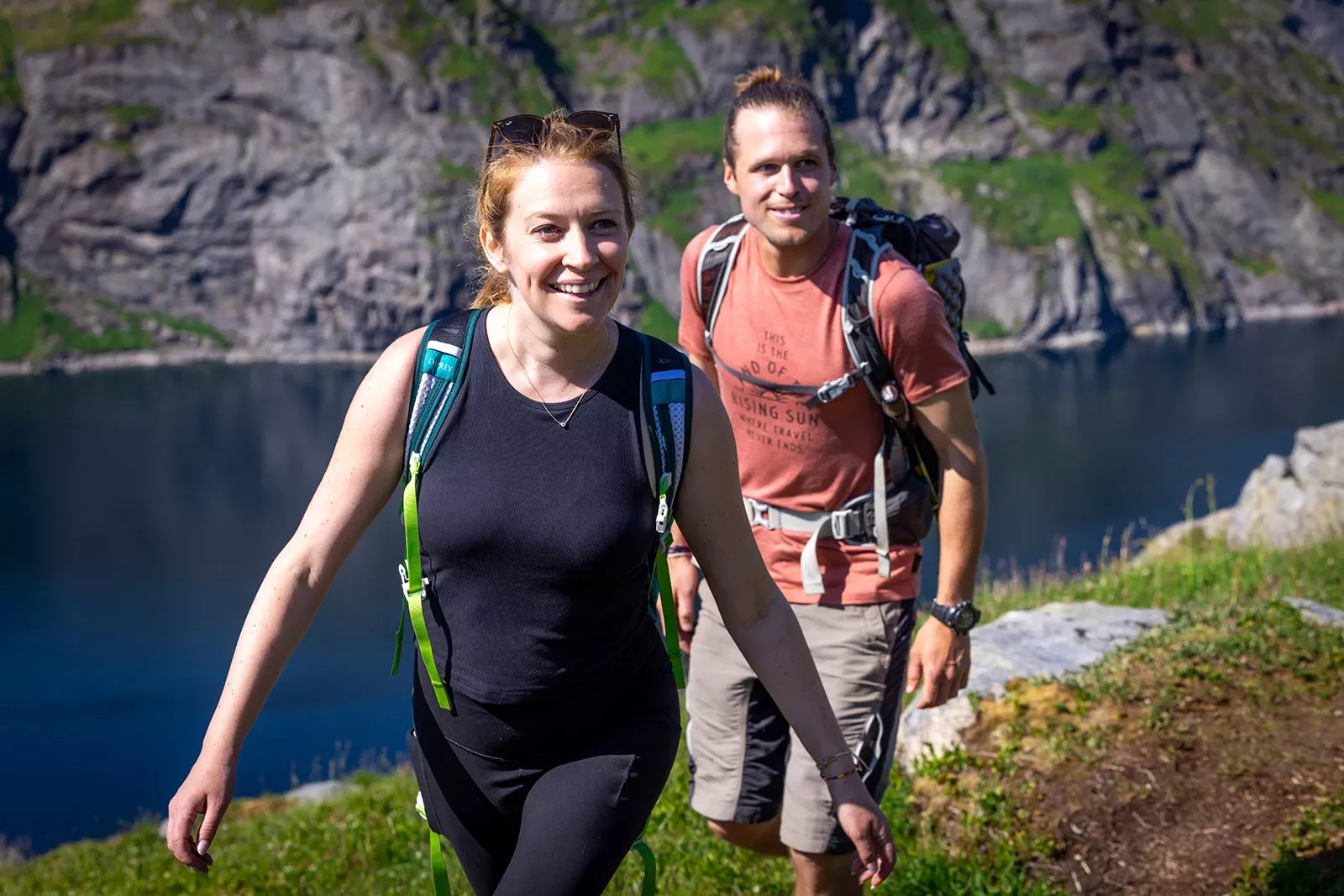 Man and women with backpacks ascending a mountain