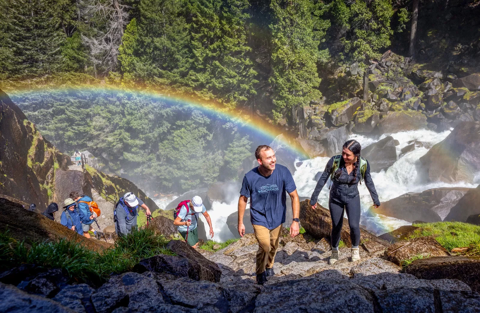 a rainbow behind a group of hikers
