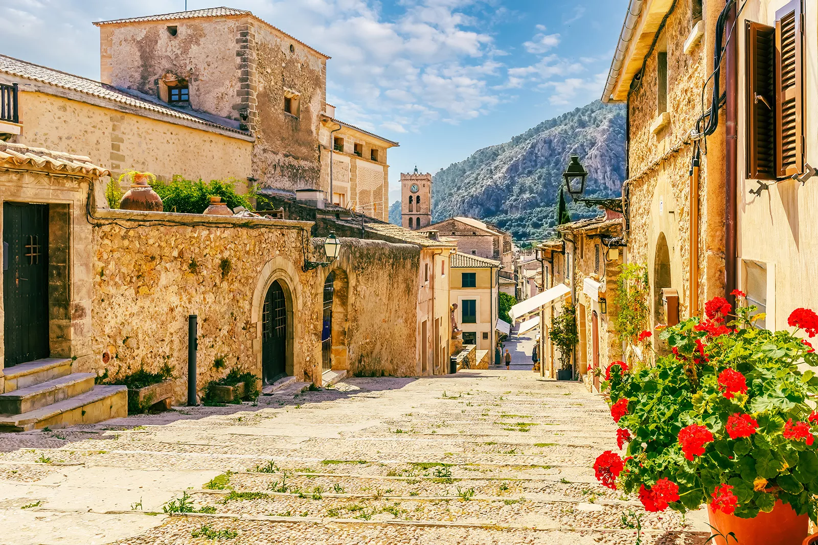 Alleyway between yellow brick buildings, with a mountain in the distance