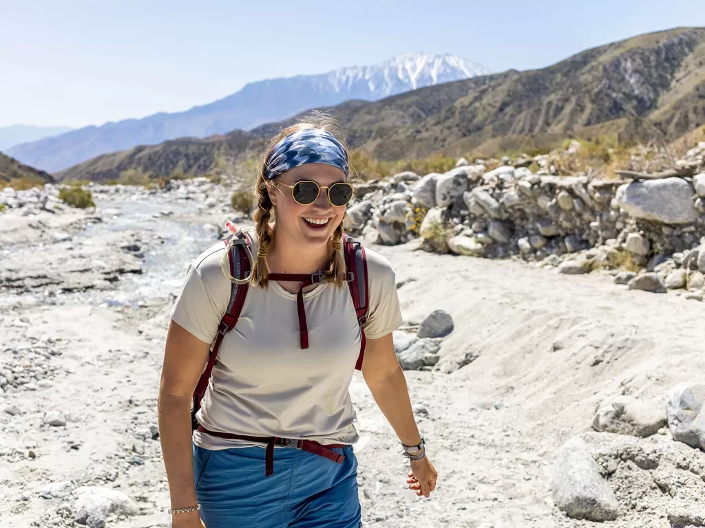 A woman hiking in the desert with mountains in the background