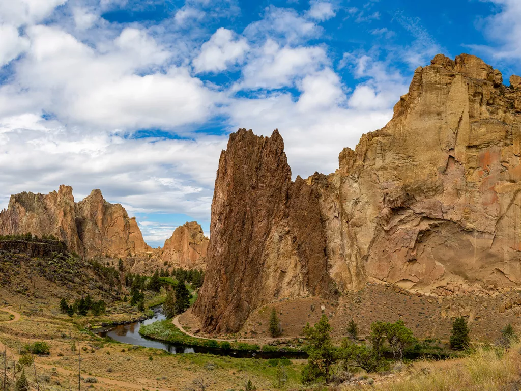 Large, jagged mountains and cliffs in a large gravel valley