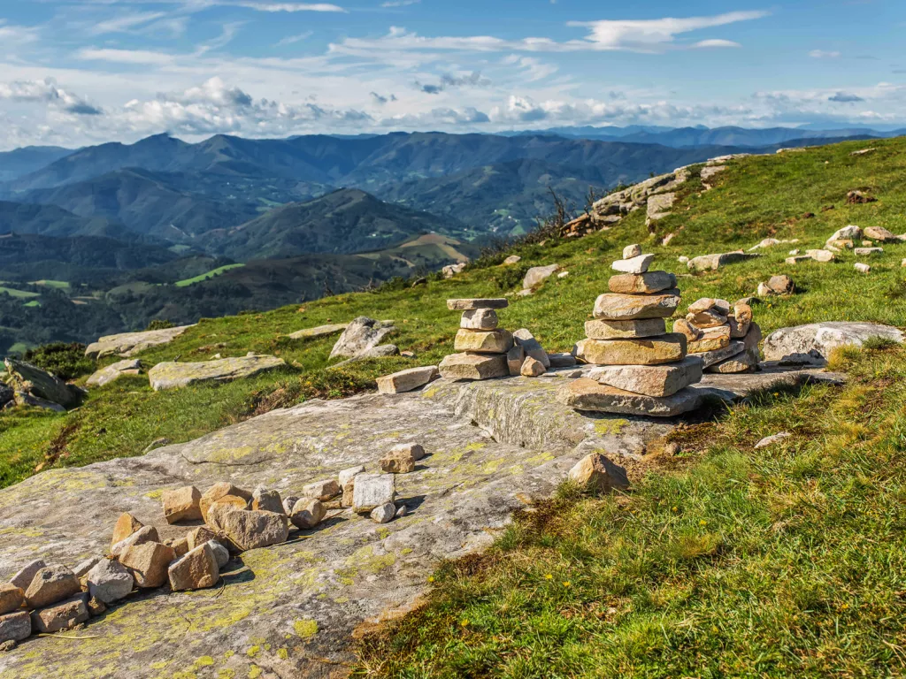 Rock slab with small towers of rocks in a grass valley