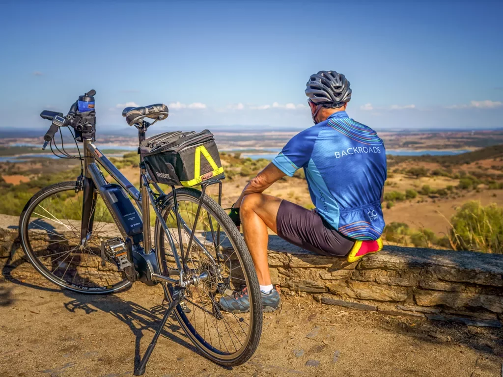 A biker with an electric bike looking towards the hills