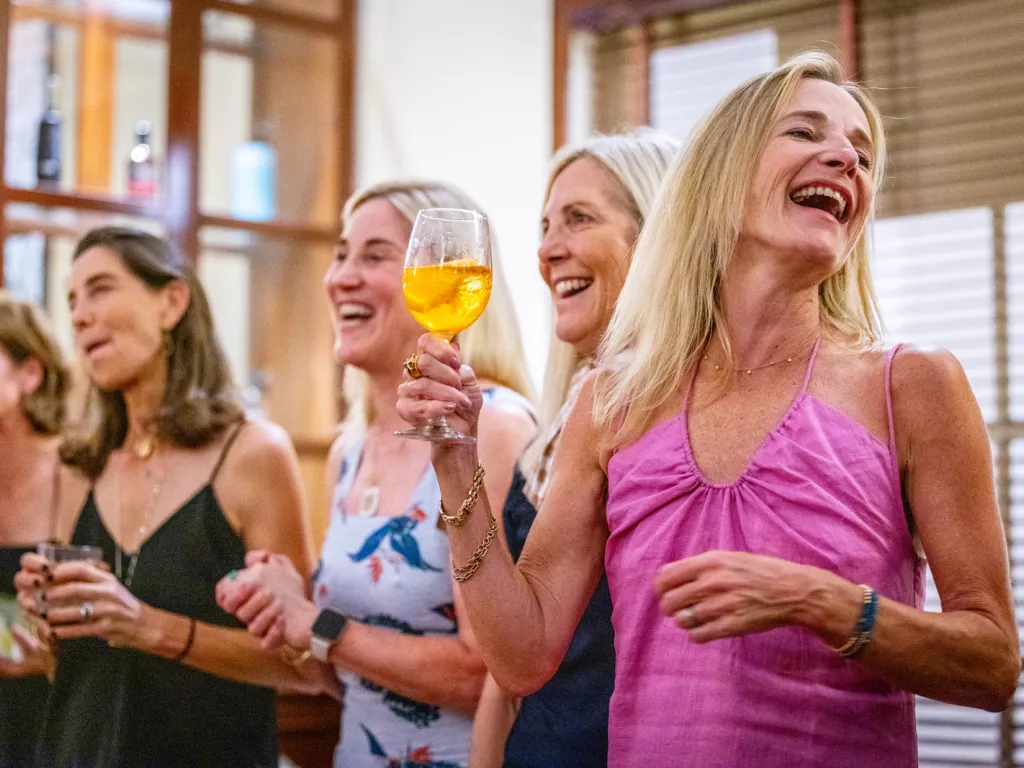 Group of women holding wine glasses and laughing