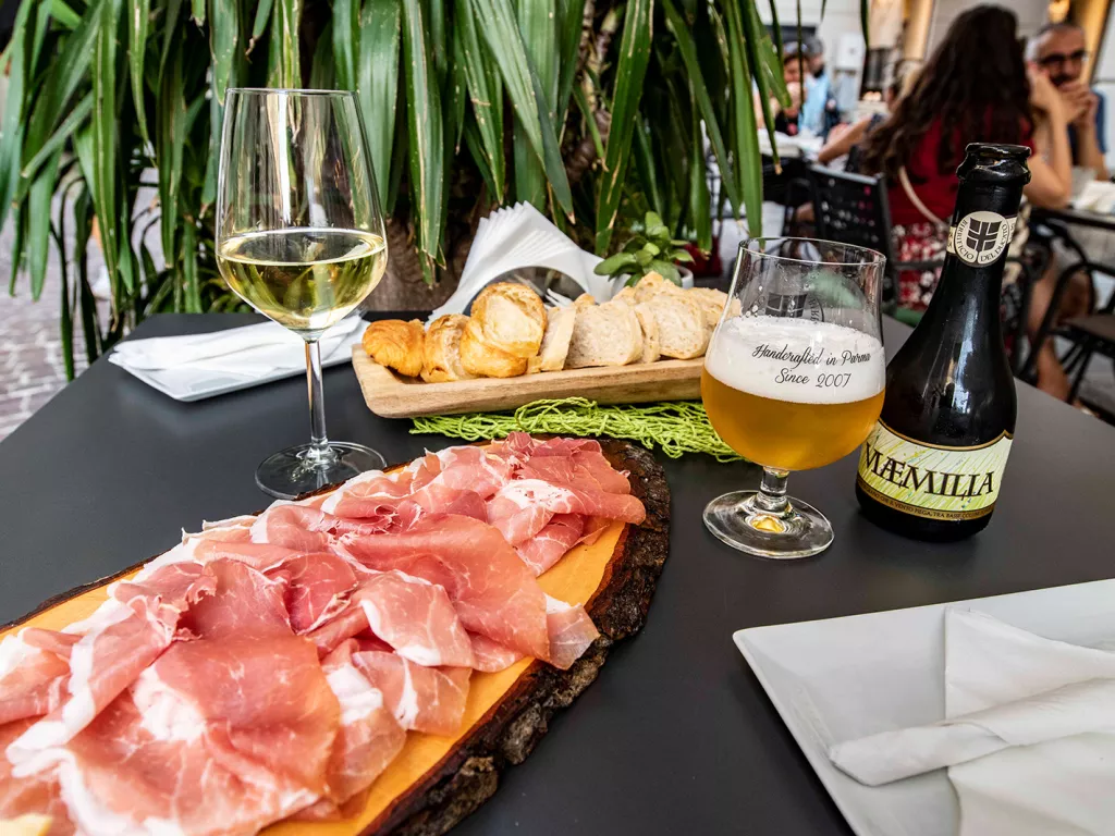 Two wooden planks full of cured meat and bread