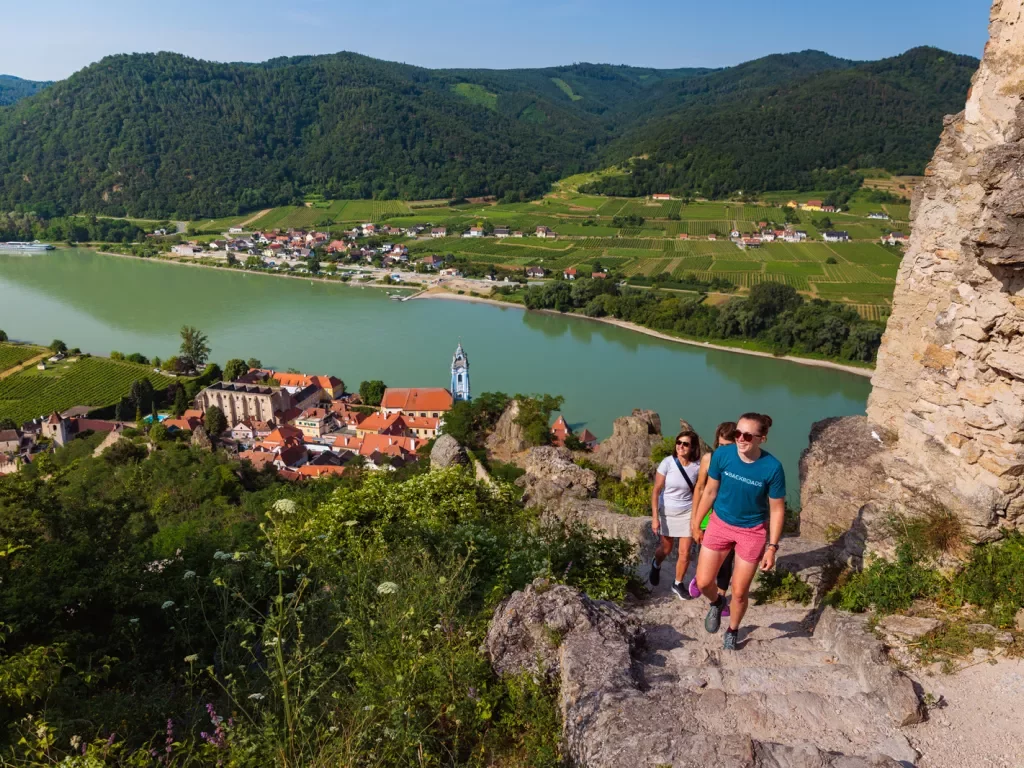 Three women hiking cliffside overlooking the water