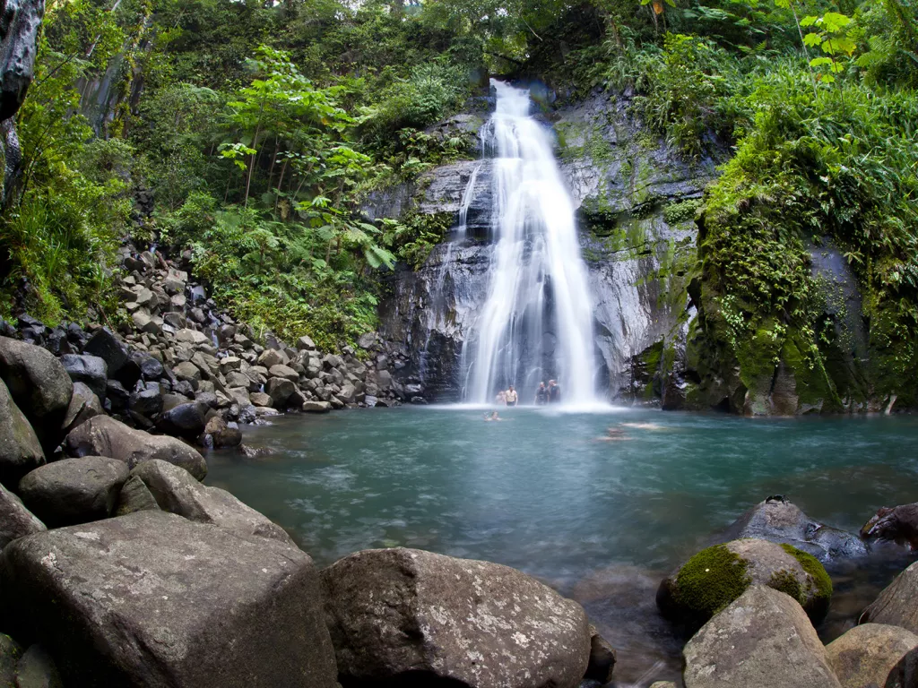 Group of people under a waterfall in a lake