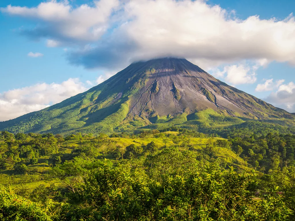 Grassy mountain covered by a cloud at its peak