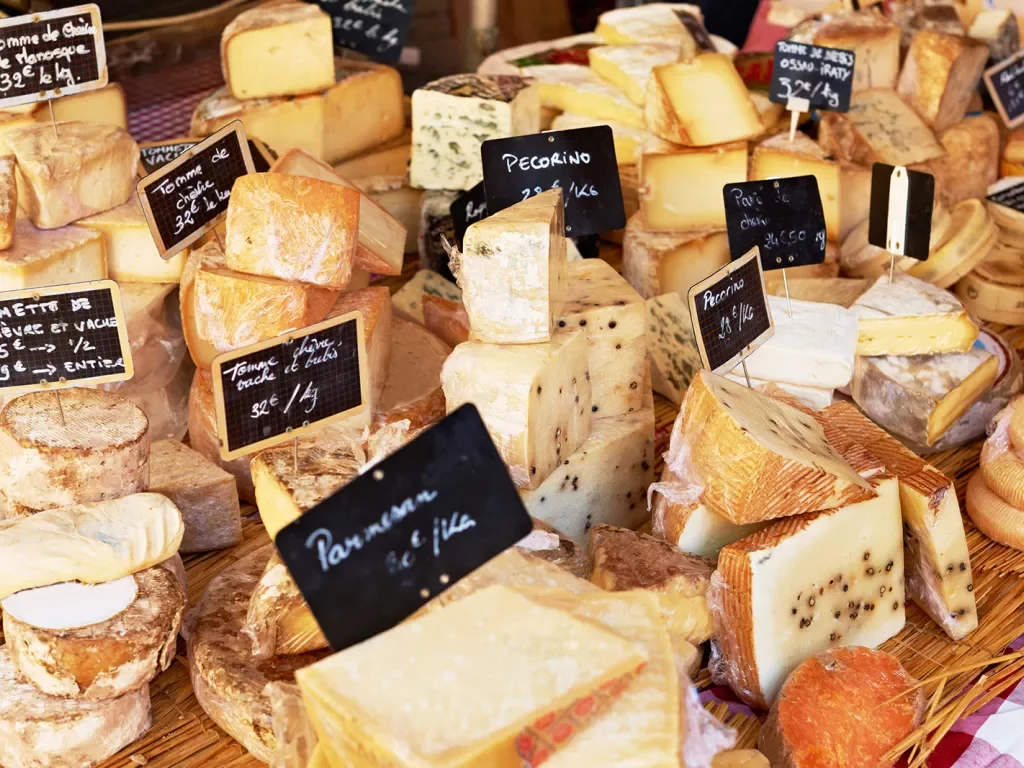 Market stand full of different cheeses with their prices on display