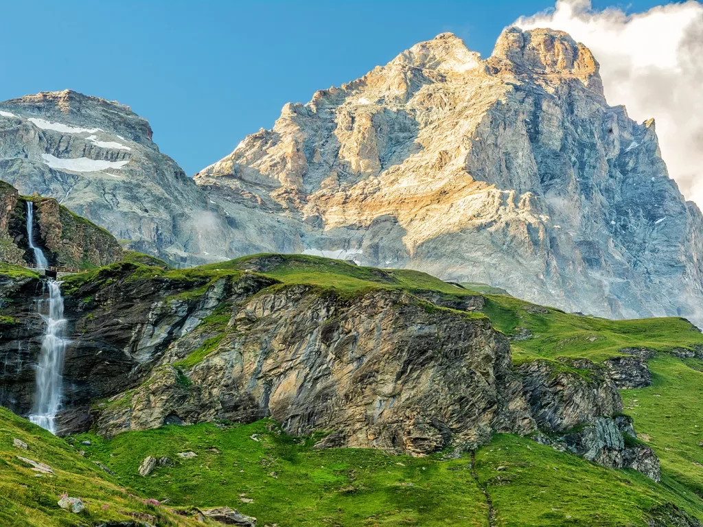 Grassy mountains in front of taller, foggy mountains