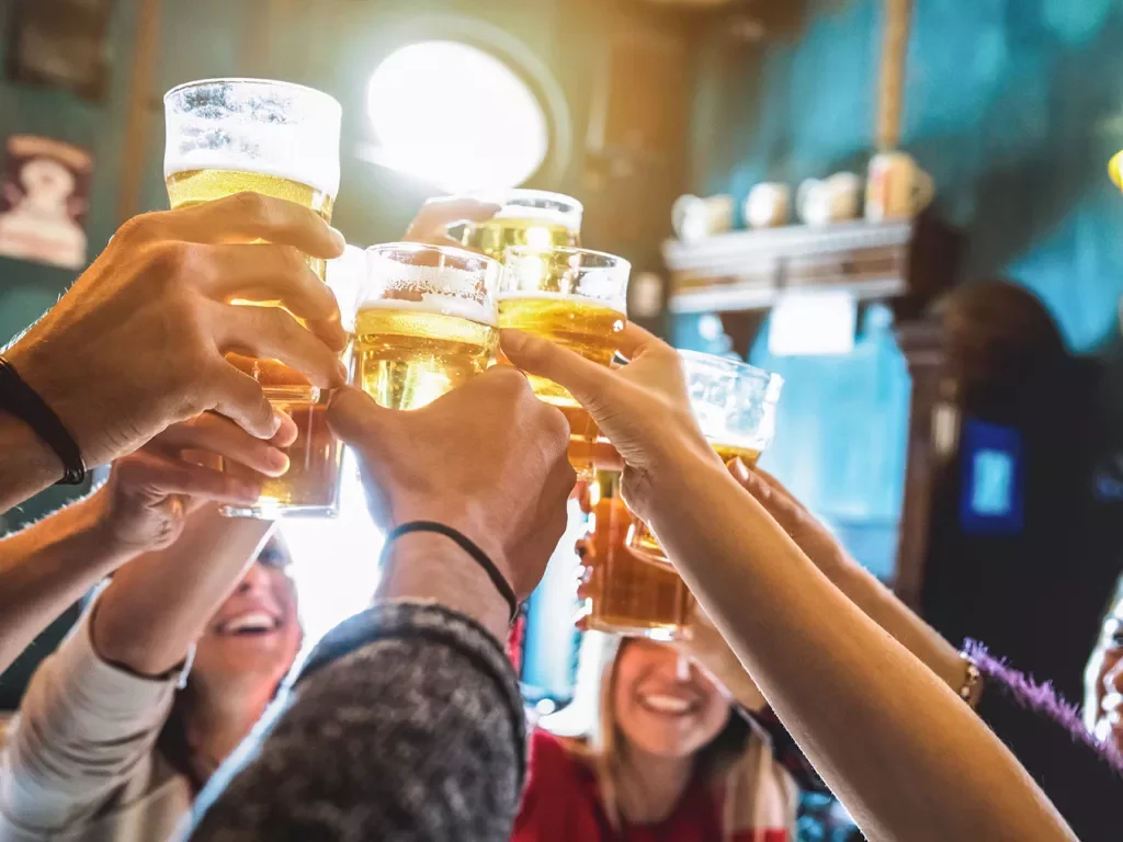 Group of people raising beer glasses for a toast