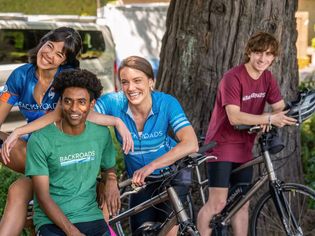 Two men and women standing arounf their bikes smiling