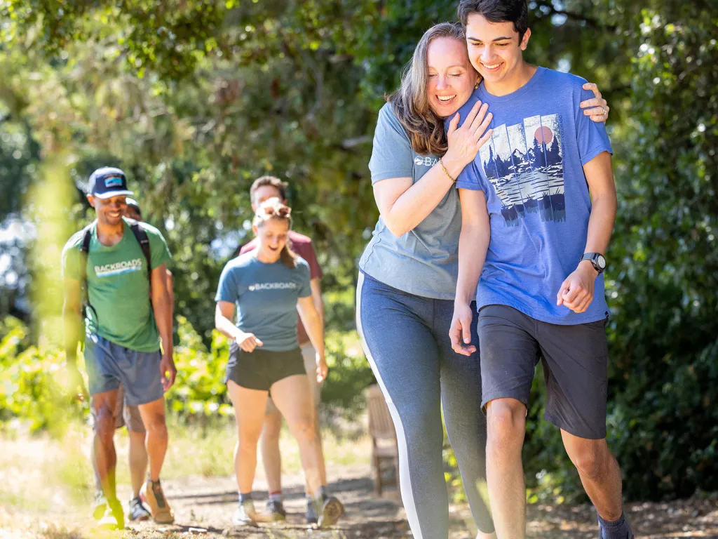 Woman hugging a man while walking on a gravel trail