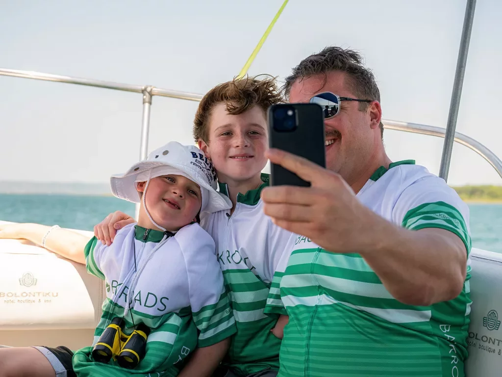 Dad and two sons taking a selfie on a boat