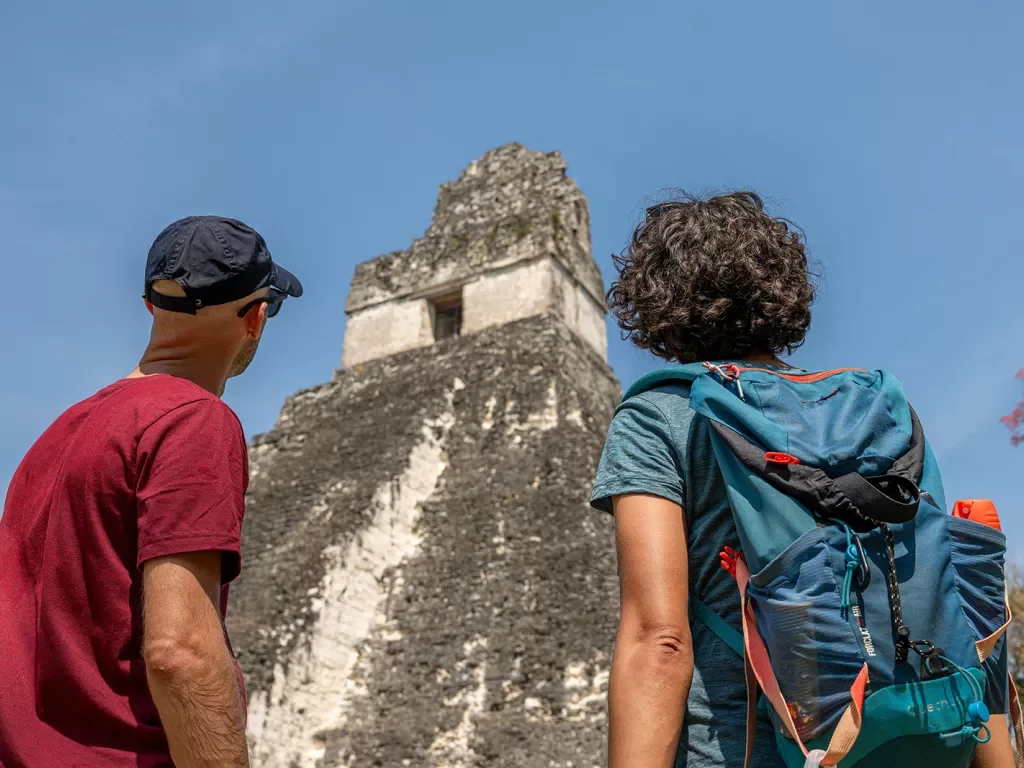 Two men looking up to an old pyramid