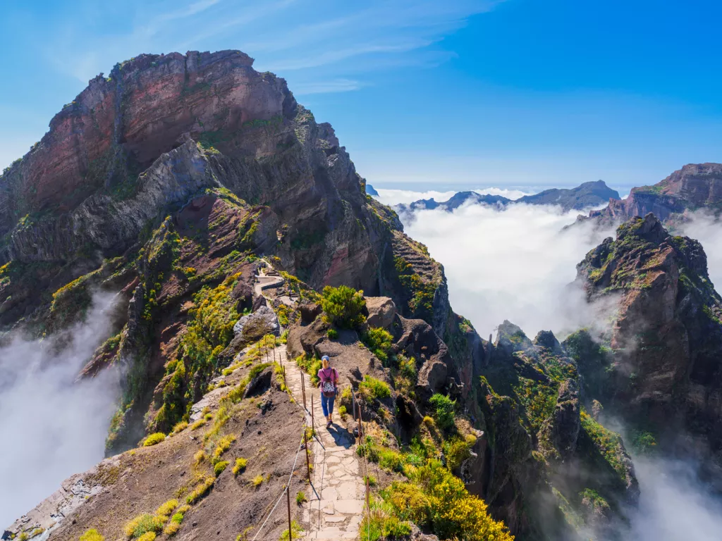 Woman hiking on a stone path on top of a foggy mountain