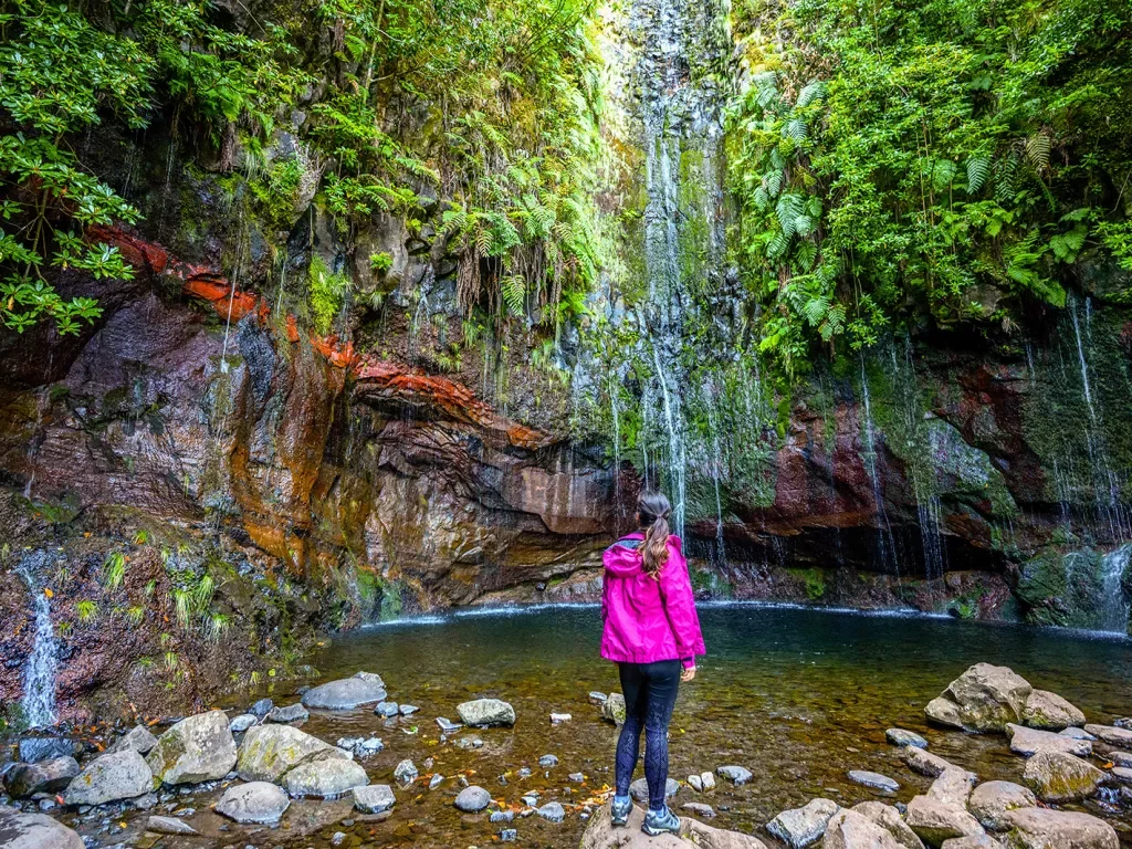 Woman standing on a rock looking at a lake 