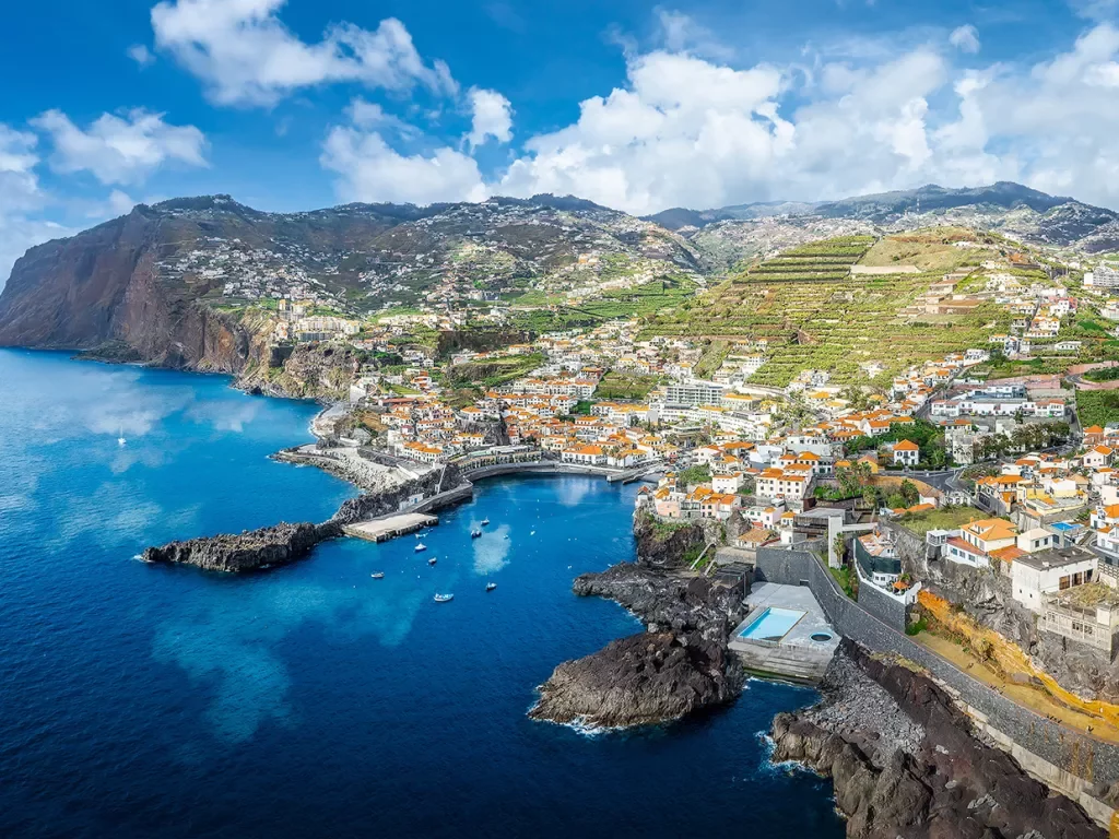 Sky view of a oceanside town with large mountains in the background