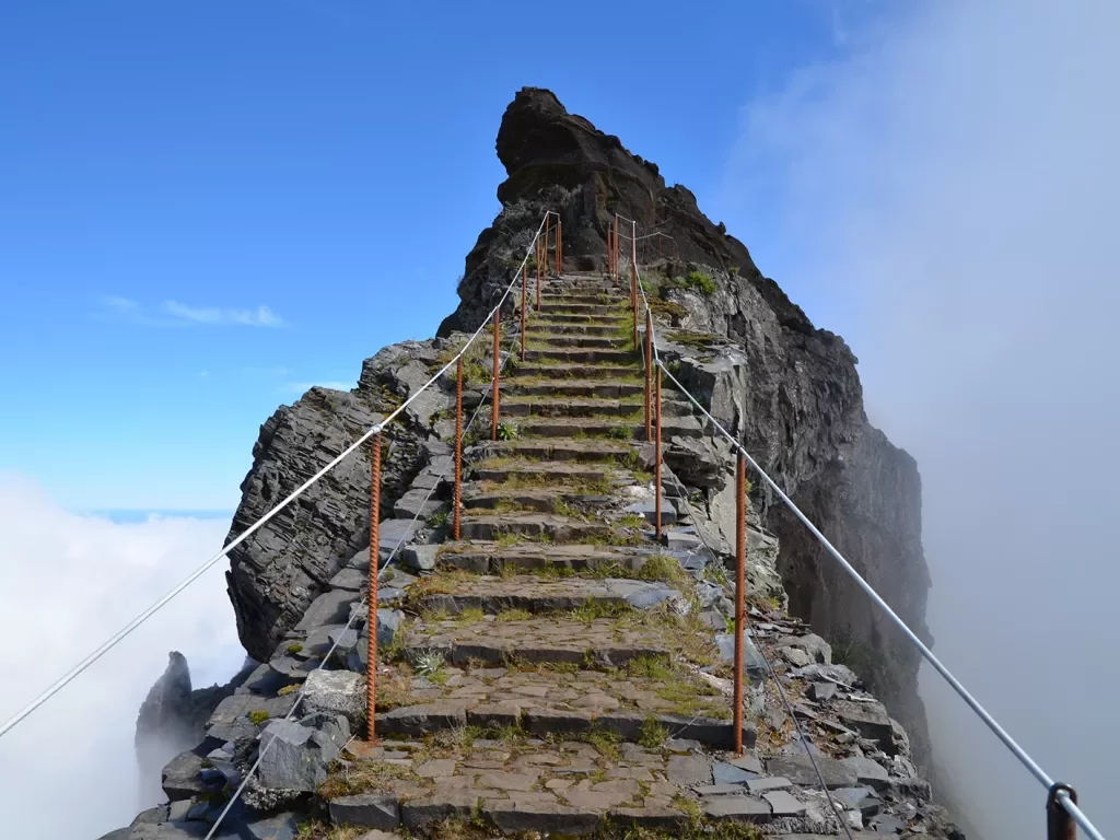 Stone stair way with metal railings leading towards the peak of a mountain