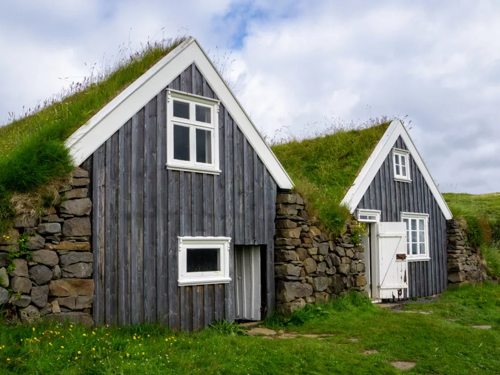 Two small cottages with grass and moss on the roof