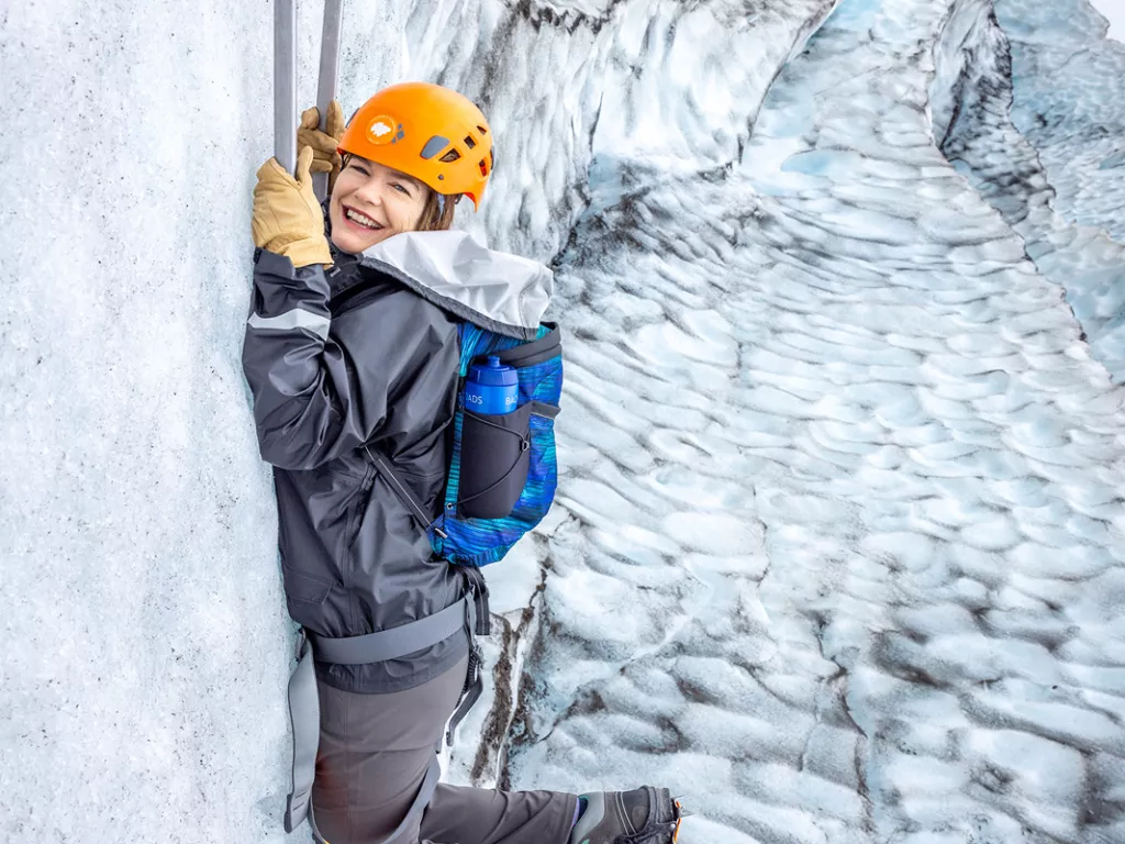 Woman hanging on to two sickles in a snowing mountain