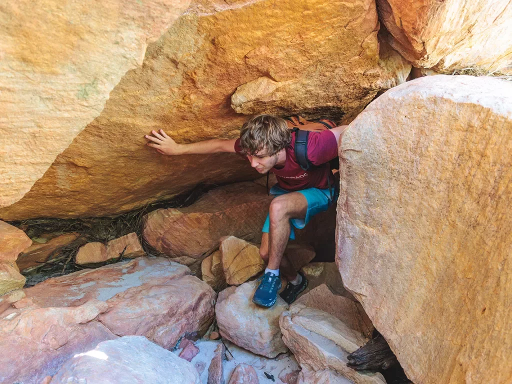 A hiker climbs through rocks