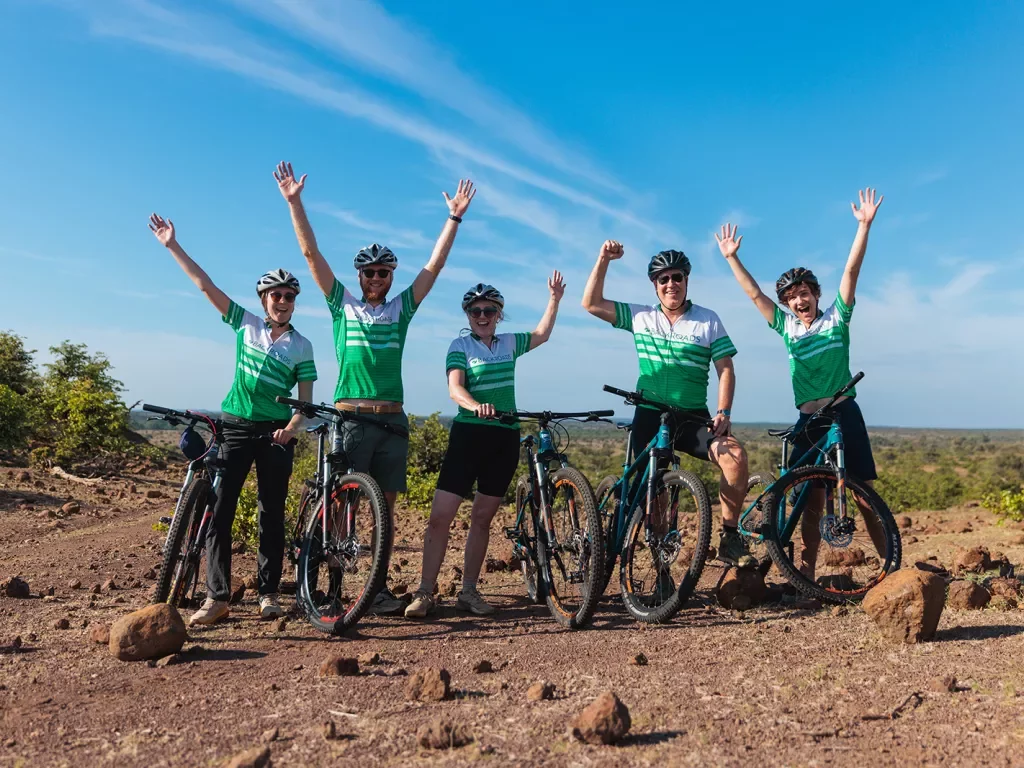 A group of people with bikes put their hands in the air