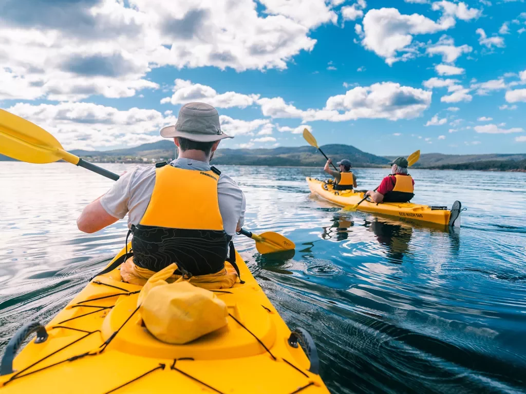 Three people kayaking in the middle of a lake