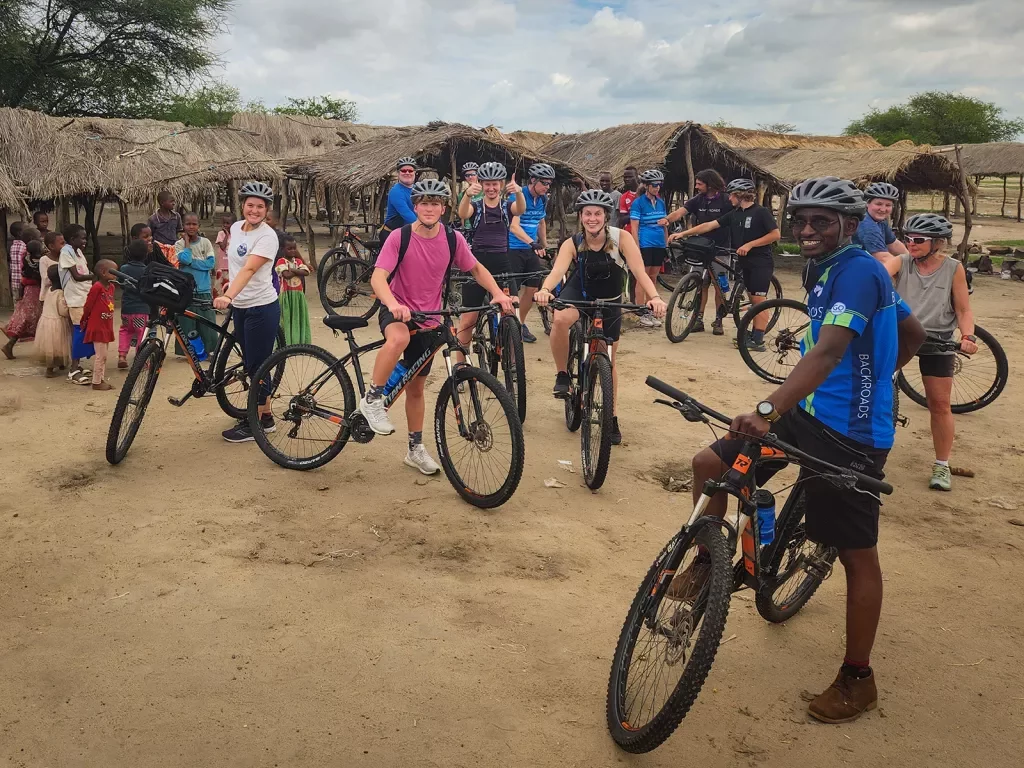 a group of people on bikes in a village