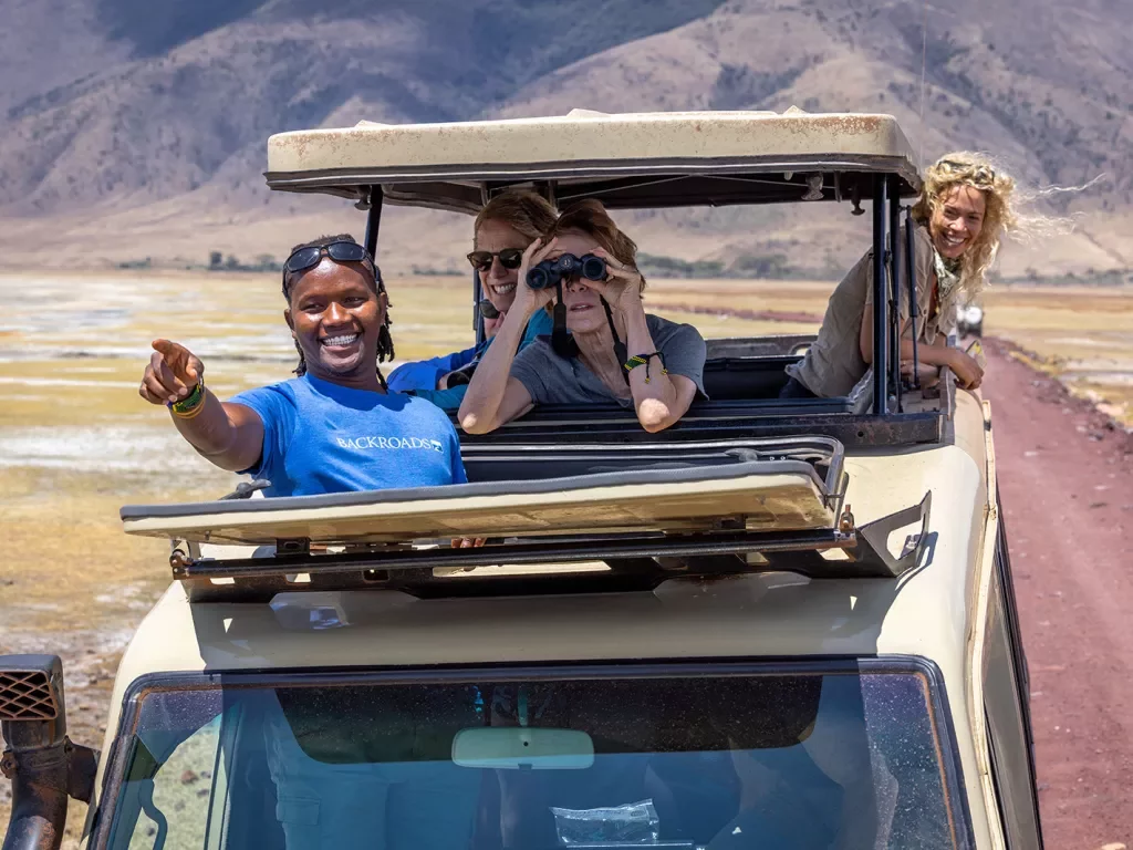 backroads guests look out of a car on safari