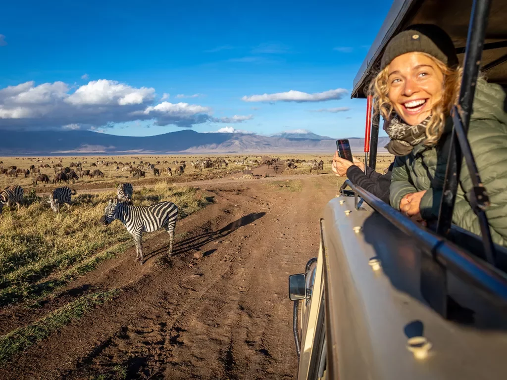 a guest looks out the window of a car on safari