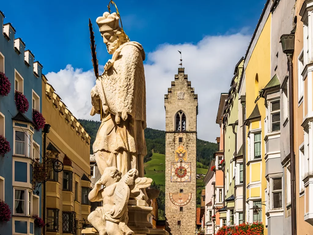 Large Spanish-style statue with a clock tower in the background