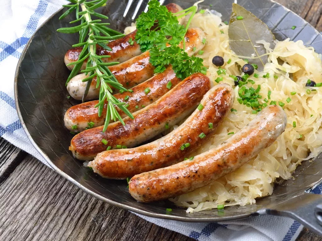 Plate full of grilled sausages and fermented vegetables