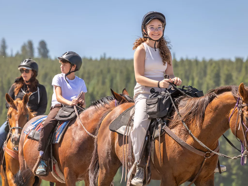 A girl smiling while horseback riding