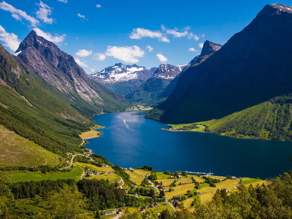 Large mountains surrounding a lake and small houses