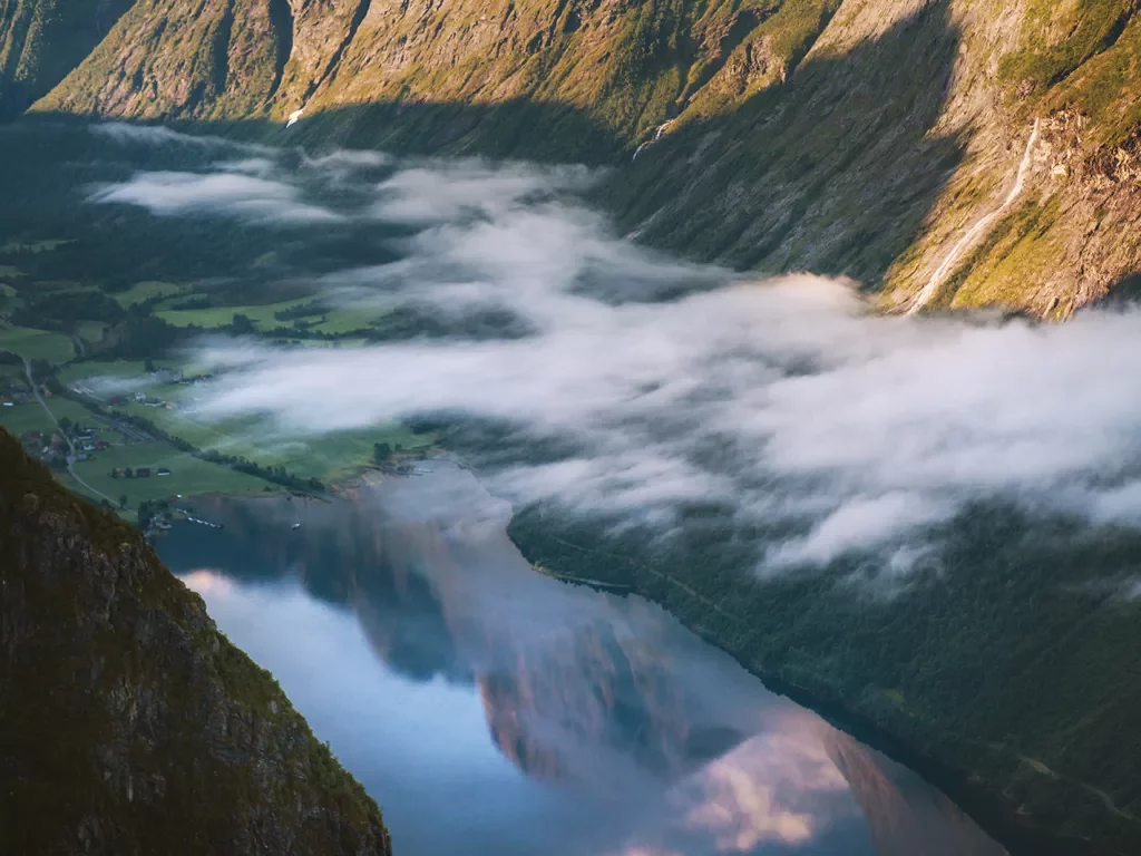 Lake between two mountains with foggy clouds