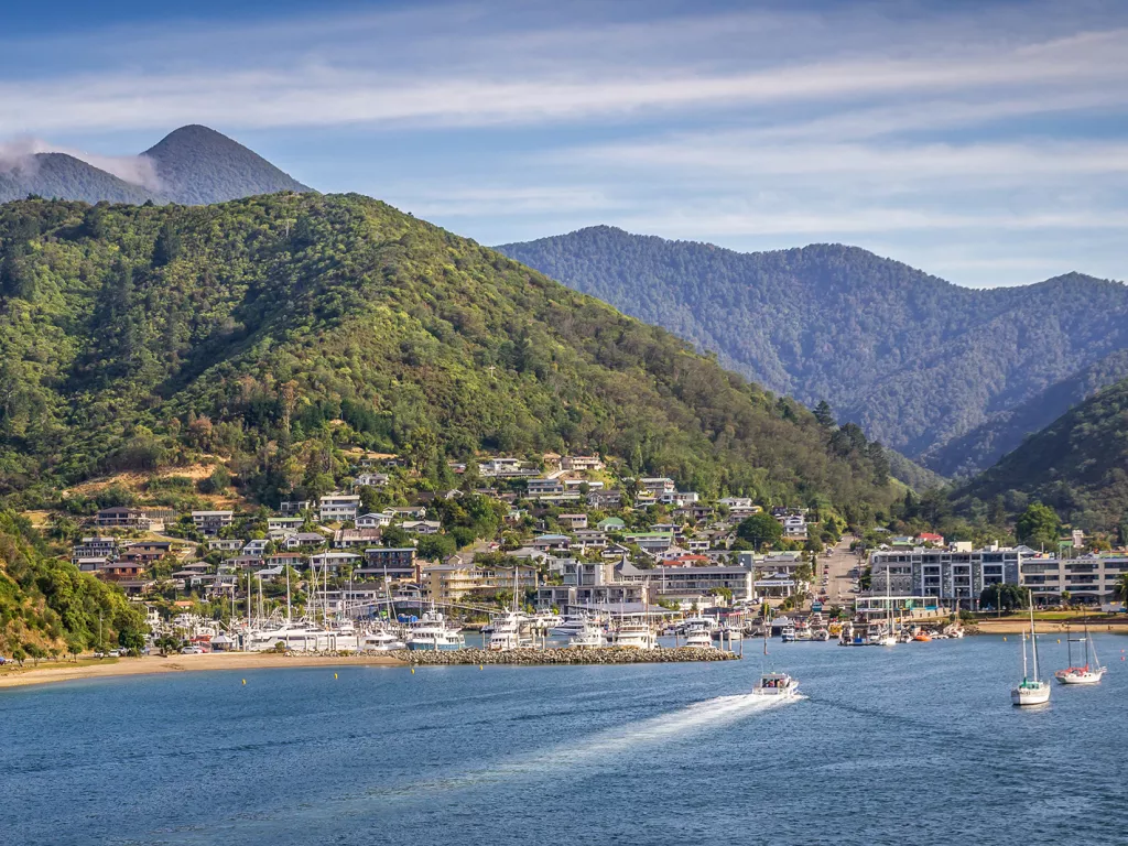 Small town next to a port with boats docked along the sand