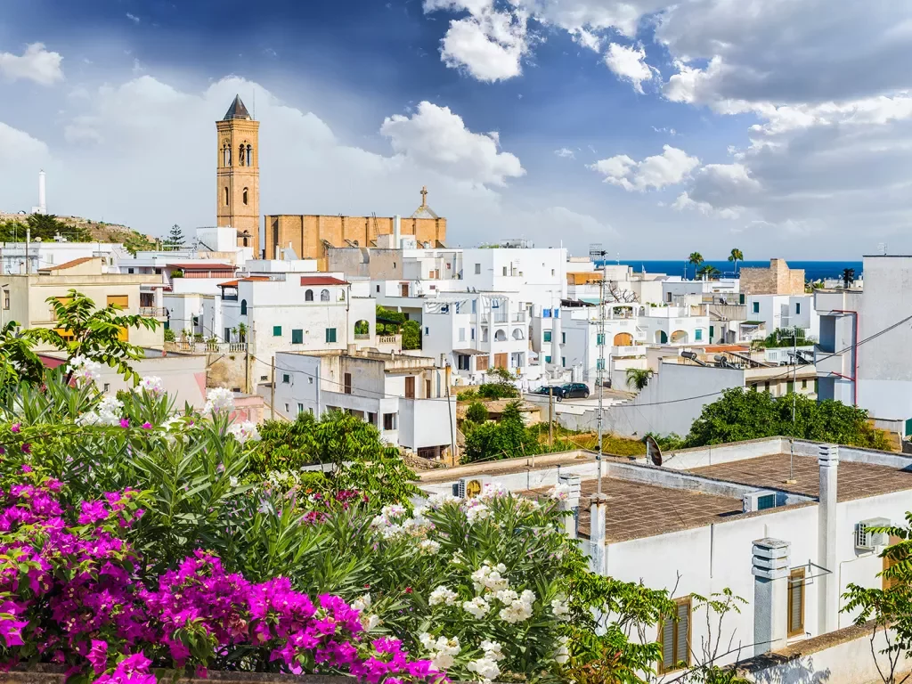 White buildings in the distance with an orange brick church building in the distance