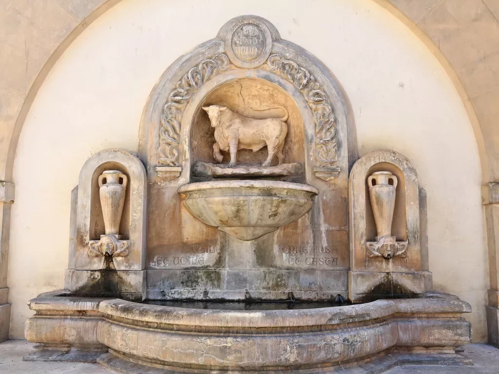 Fountain with a bull in the center and two vases on either side