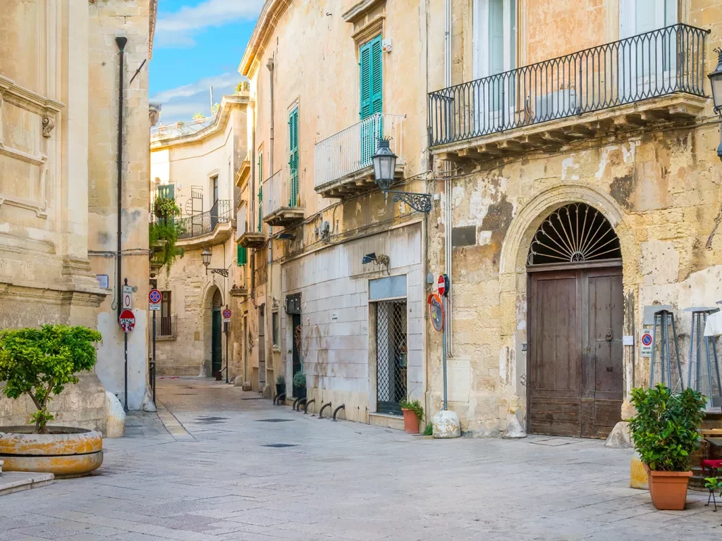 Alleyway of a town with outdoor seats and yellow buildings