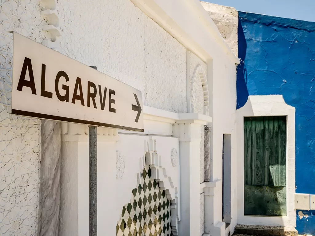 A sign pointing to a blue building with the word "Algarve"