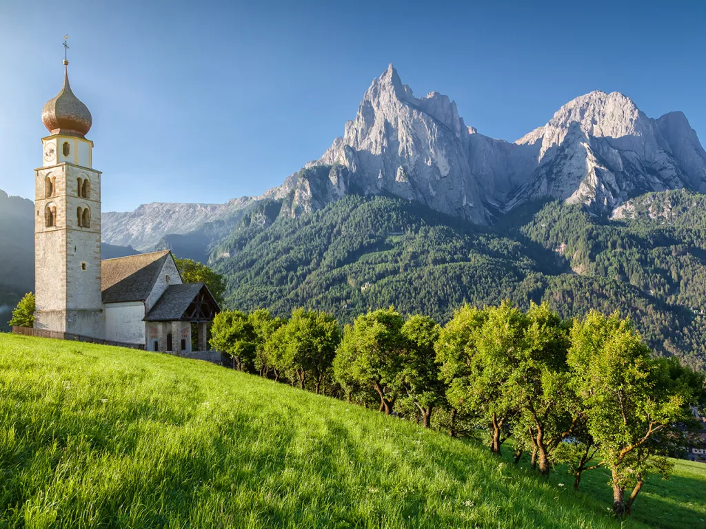 Rustic church next to a tall mountain in the background