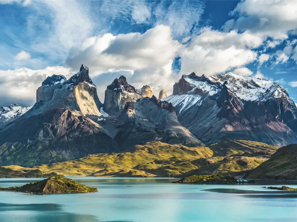 Lake with snow-capped mountains and clouds in the distance