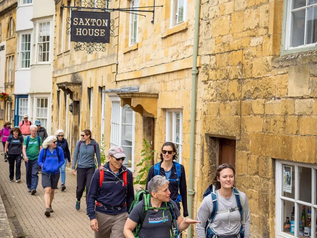 Group of people walking on a stone pathway next to brick buildings