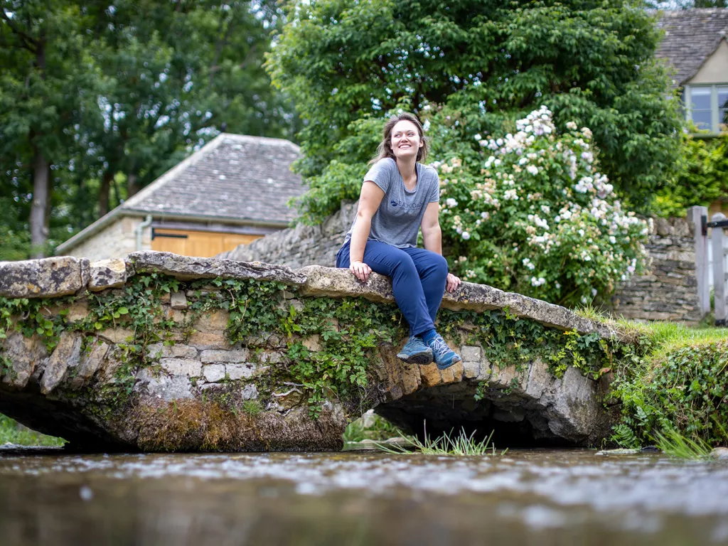 Woman sitting on a stone bridge looking to the left