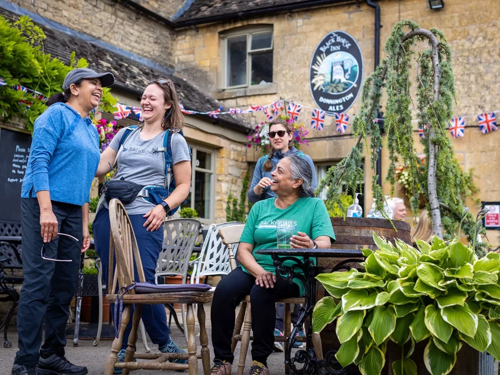 Four women laughing and smiling in an outdoor patio
